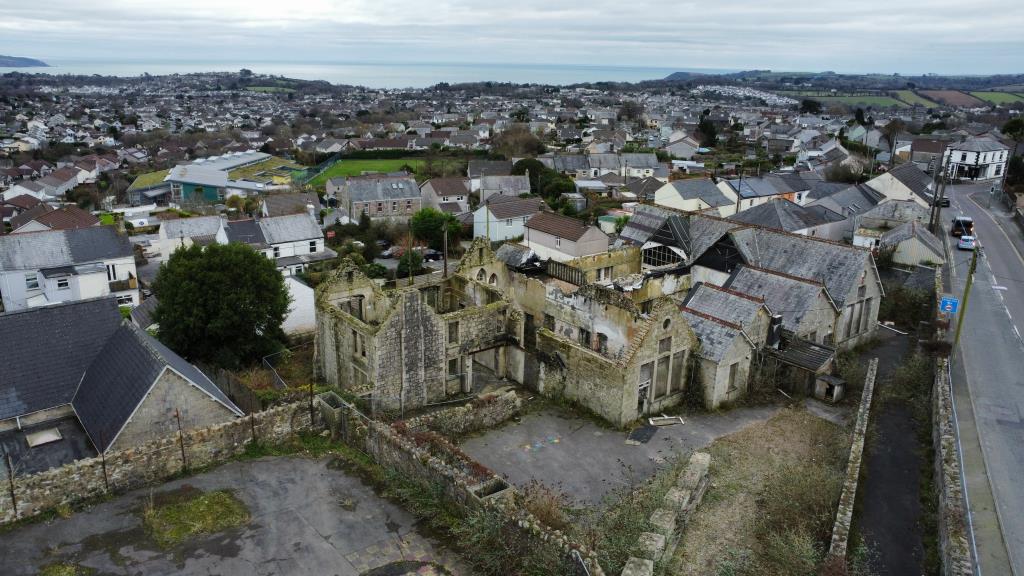 Lot: 56 - SUBSTANTIAL FORMER SCHOOL PREMISES - Aerial photo showing buildings and sea in the background